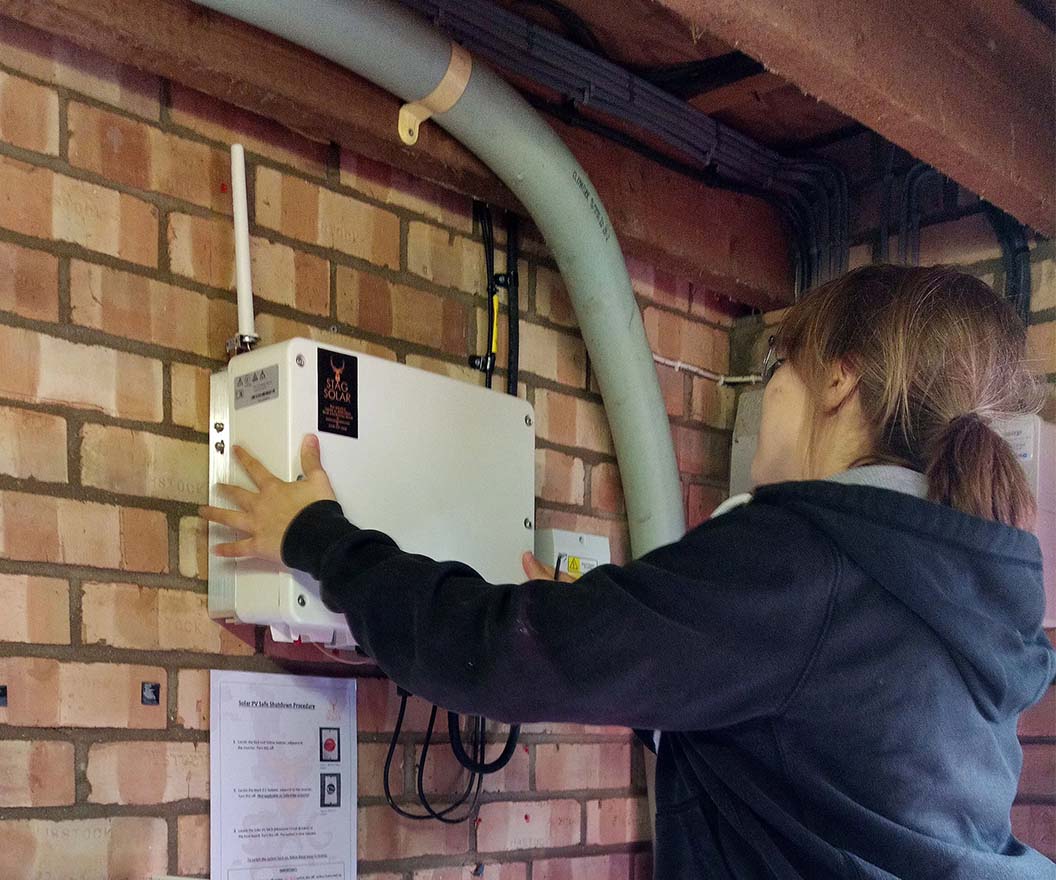 Commercial solar maintenance in Braintree showing technician inspecting inverter and electrical system